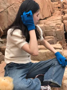 Nahaufnahme von blauen Damen Strickhandschuhen, süße warme Fünffinger Handschuhe mit Schleife.