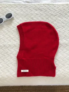 Vue détaillée du tissu tricoté en laine rouge et de l'étiquette de composition claire.