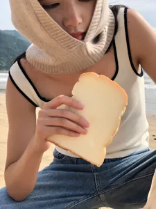 Détail bonnet cagoule tricoté, couvre-chef en mélange de laine douce sur la plage.