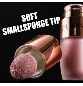Detailopname van vloeibare highlighter contour stick met zachte sponskop en dop.