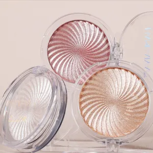 Close-up detail of three swirl highlighter pressed powder palettes in clear plastic cases.