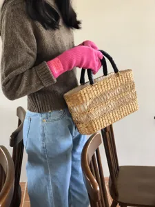 Nahaufnahme von kuscheligen Winterstrickhandschuhen in Rosa mit weicher Wollstruktur.
