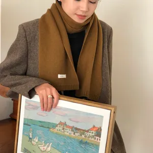 Nahaufnahme eines weichen braunen Wollschals am Modell, eleganter Winter-Accessoire-Stil.