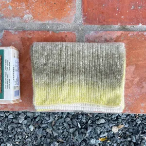Primer plano detallado de una bufanda de punto degradado suave con textura fina.