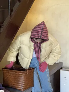 Houndstooth knitted balaclava hat and scarf combo, indoor lifestyle detail shot, cozy winter knitwear.