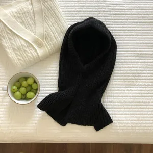 Close-up of black knitted balaclava hooded scarf, soft warm wool knit texture detail shot.