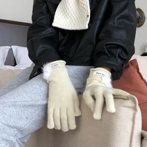 Nahaufnahme der warmen Winterstrickhandschuhes mit süßem Bommel und Touchscreen-Funktion.