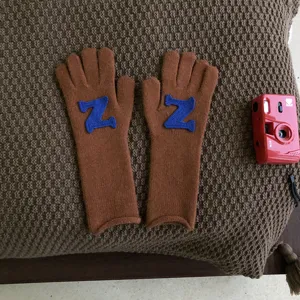Detailaufnahme brauner Strickhandschuhe mit blauem Z-Aufnäher, kuschelige Winter Handschuhe