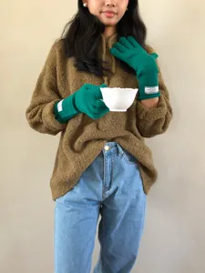 Detailaufnahme von warmen Strick-Touchscreen-Handschuhen in Grün für den Winteralltag.