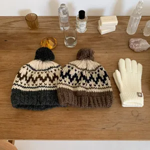 Cozy knit beanie and warm winter gloves set, classic Nordic pattern with fluffy pom pom.