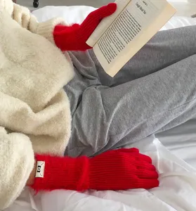 Nahaufnahme der kuscheligen roten Strickhandschuhe mit weicher Textur für den Winter.