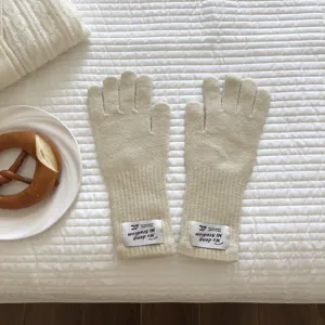 Kuschelige Strick-Fingerhandschuhe Detailansicht mit Rippbündchen und schickem Label.