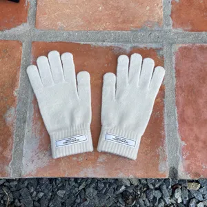 Detailansicht weißer Strick-Wärme-Fünffingerhandschuhe aus weichem Wollmaterial für den Winter.