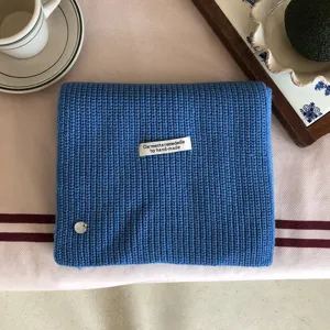 Nahaufnahme Detailansicht des weichen blauen Strickwollschals mit handgemachtem Etikett.