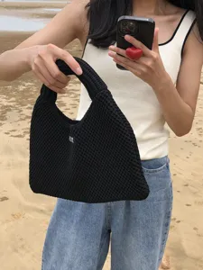 Detailansicht der schwarzen gestrickten Beuteltasche mit hochwertiger Webtextur und Stil.