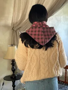Knit plaid hooded shawl detail, cozy winter neck warmer and stylish fabric texture view.