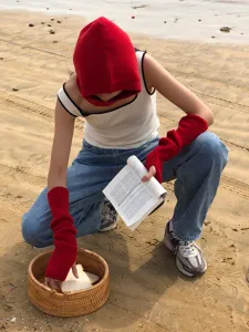 Detailed view of soft red knit arm warmers, cozy winter fashion accessory outdoor.