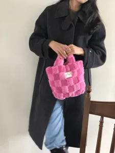 Detailed view of the soft pink plush checkerboard handbag, showing cozy winter fluffy texture.
