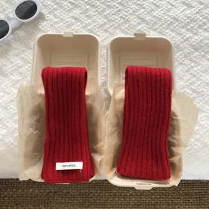 Red knitted wool arm sleeves detail view in eco-friendly gift box packaging style