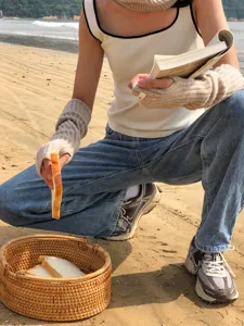 Detailed shot of knitted arm warmers on beach, soft texture and cozy winter accessory.