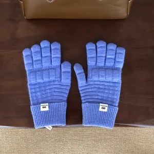 Detailansicht blauer Waffelstrick-Handschuhe mit Strukturmuster und Rippbündchen.