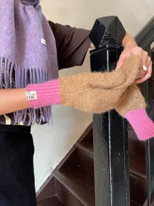 Women winter wool scarf and knit gloves detail shot, warm fringe wool shawl and colorblock mittens.