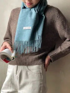 Detail view of the winter warm wool fringe scarf showing soft texture and product label.