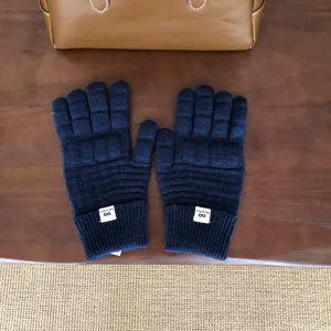 Nahaufnahme dunkelblauer Strick-Waffelhandschuhe mit Rippbündchen und weicher Wolle.