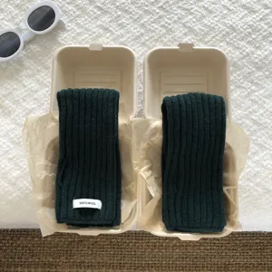 Detailed view of dark green knitted half-finger gloves warm wool sleeves in paper boxes