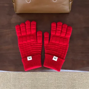 Detailaufnahme roter Winter-Strick-Waffelmuster-Fünffingerhandschuhe mit Bündchenetikett.