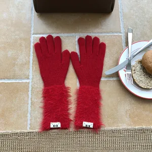 Rote lange Strick-Touchscreen-Handschuhe mit Plueschbuendchen und einfarbigem Design.