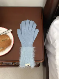 Detailansicht langer Strickhandschuhe mit Plüschbündchen in hellem Blau, kuschelig weich.