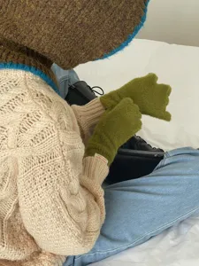 Cozy winter color-blocked knitted balaclava hat paired with stylish sweater and warm fuzzy gloves.
