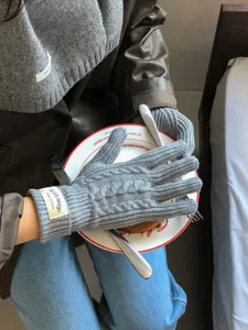 Grey cable knit gloves for women, cozy winter thermal five-finger knitwear detail shot.