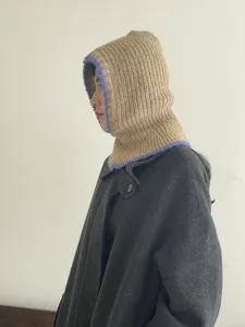 Detailed side view of a stylish two-tone knitted balaclava hood and scarf in one.