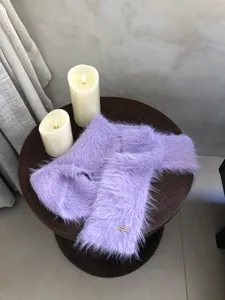 Detalle de bufanda estrecha de suave piel sintética en color lavanda sobre mesa.