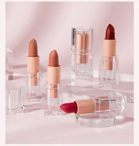 Matte nude lipstick detail view, transparent acrylic display stand, soft pink background aesthetic.