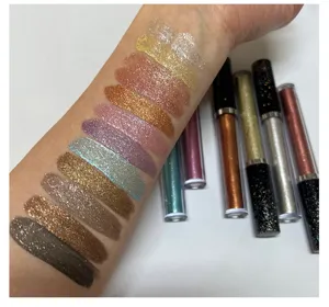 Close-up of liquid eyeshadow swatches on arm showing glitter and shimmer textures clearly.
