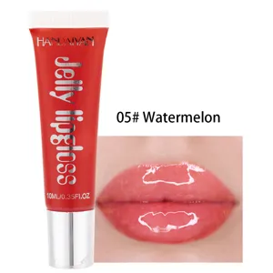 Gros plan détail tube de gloss à lèvres rouge brillant et échantillon sur les lèvres.
