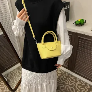Stylish yellow mini handbag with top handle and adjustable shoulder strap for daily wear.