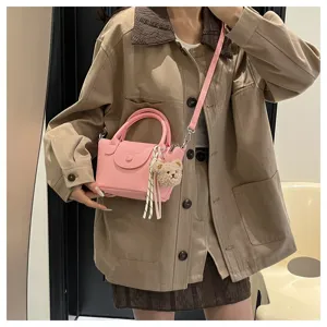 Trendy pink women handbag with cute bear pendant, stylish casual shoulder crossbody bag detail.