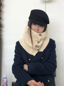 Detail shot of the stylish knitted neck warmer scarf in beige, featuring button closure design.