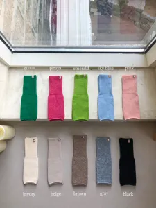 Detailaufnahme von gestrickten fingerlosen Armstulpen in verschiedenen Farben, Rippenoptik.