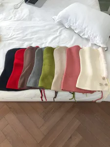 Close-up detail view of colorful knitted balaclava hoods, warm winter wool hats with drawstrings.