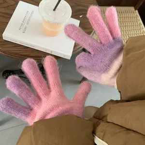 Close-up of cozy gradient knitted gloves in pink and purple, soft winter warm thermal wear.