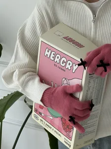 Süße rosa Strickhandschuhe mit zarten schwarzen Schleifen, perfekte Detailansicht für Winter.