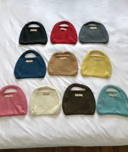 Detailansicht bunter Strick-Handtaschen mit verschiedenen einfarbigen Optionen und Texturen.