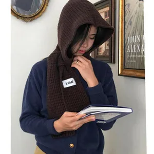 Detailed shot of a cozy brown knitted hooded scarf, perfect for winter warmth and wind protection.