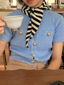 Zwart-wit gestreepte gebreide driehoekige sjaal gecombineerd met blauw vest voor de herfst.