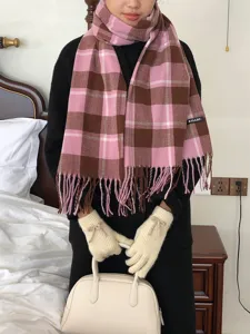 Detailansicht des rosa-braunen Karo-Schals mit Quasten und eleganten Handschuhen.